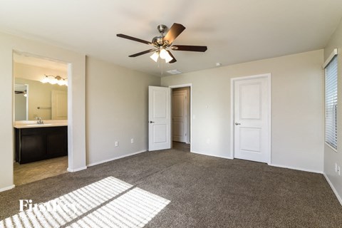 a living room with carpet and a ceiling fan