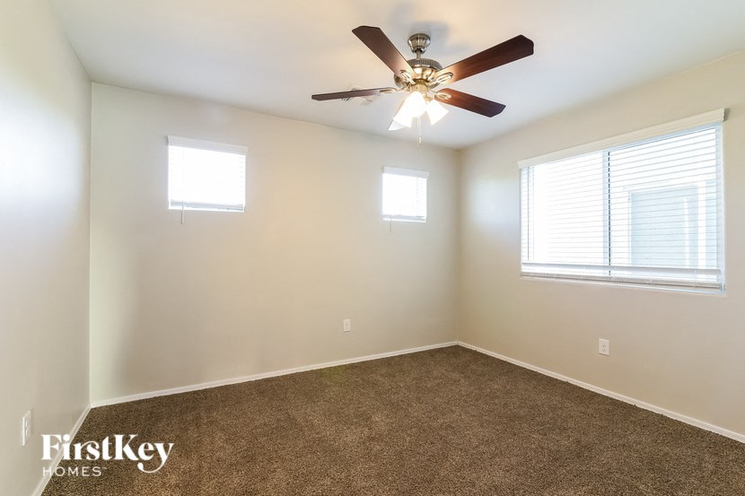 a bedroom with a ceiling fan and a window