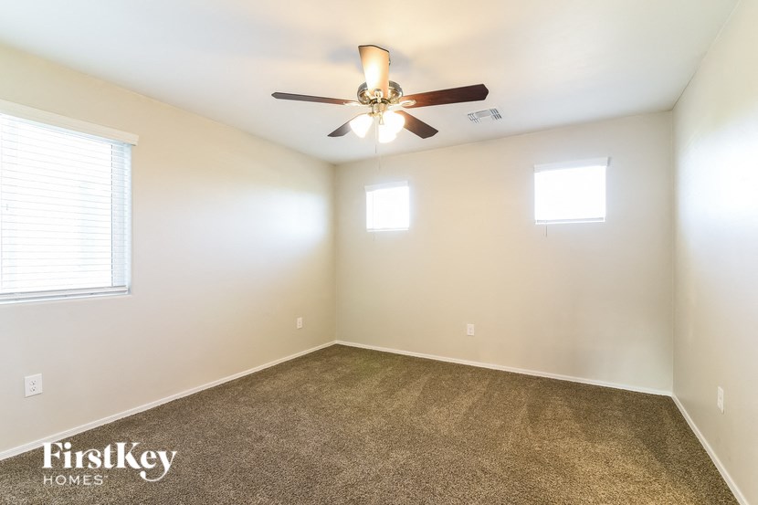 a living room with carpet and a ceiling fan