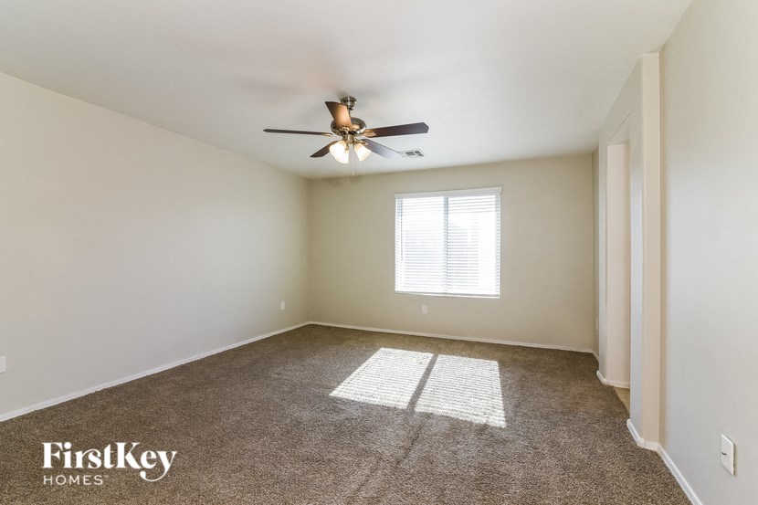 an empty room with a ceiling fan and a window