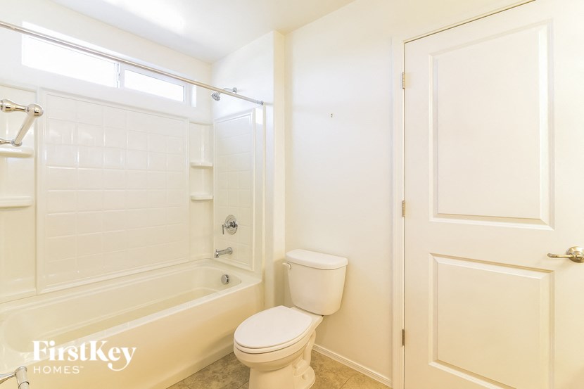 a white bathroom with a tub and a toilet