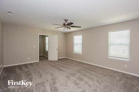 a living room with carpet and a ceiling fan
