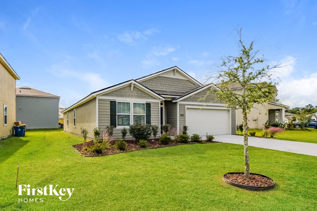 a house with a lawn and a tree in front of it