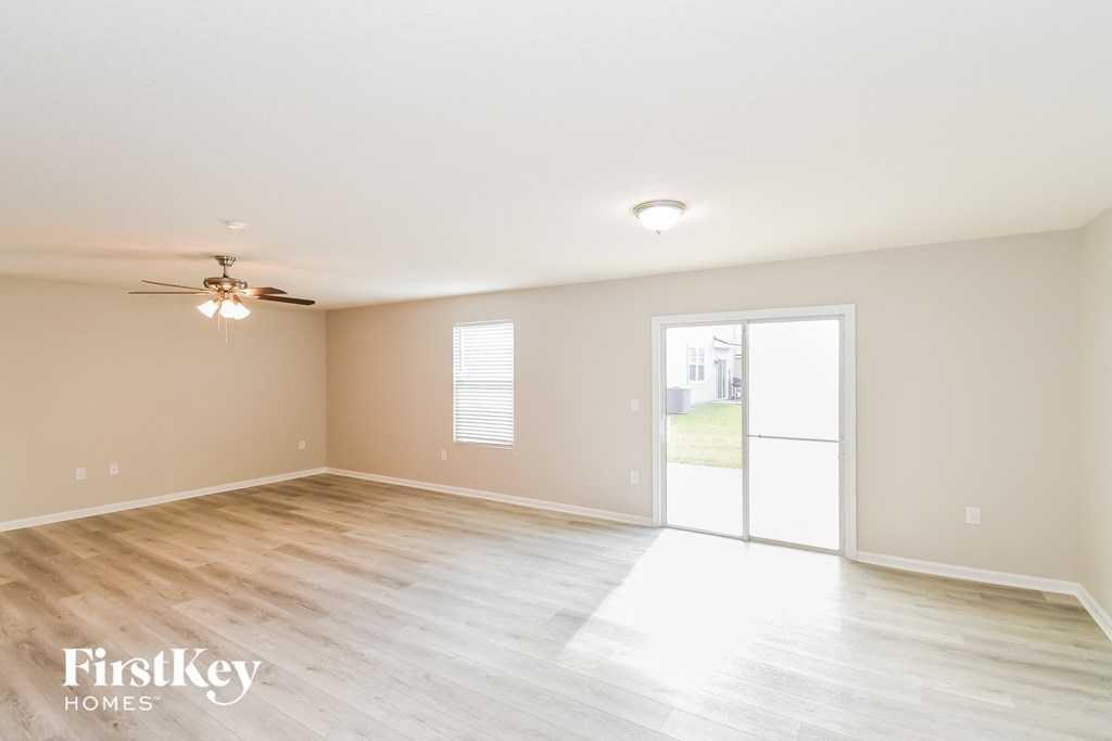 a living room with a sliding glass door and a ceiling fan