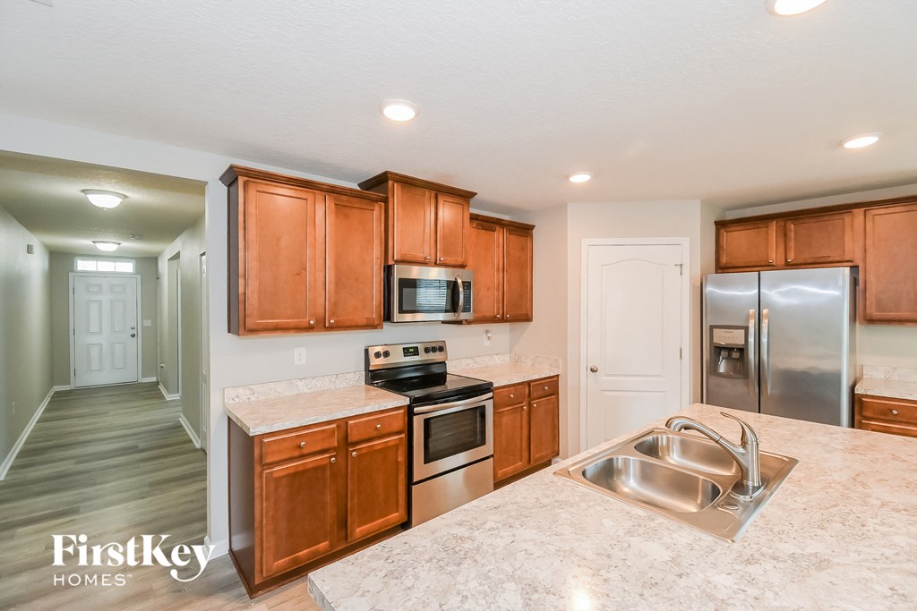 a kitchen with wooden cabinets and stainless steel appliances