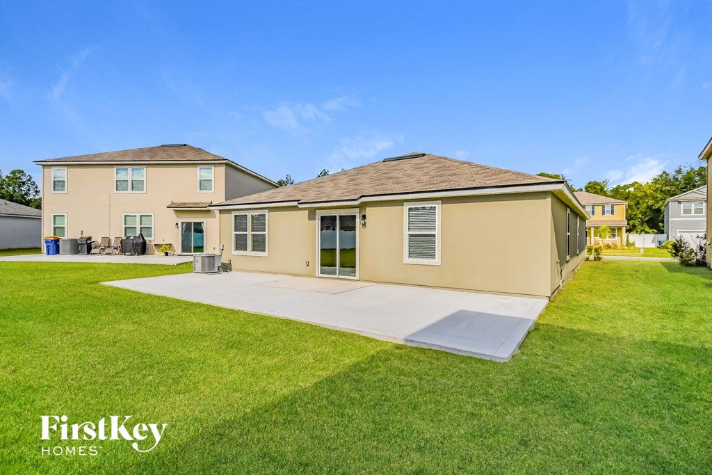 a beige house with a yard and a driveway