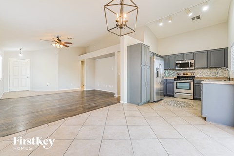 A kitchen with a refrigerator, oven, and microwave.