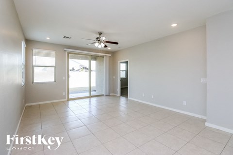 A spacious room with a ceiling fan and sliding glass doors.