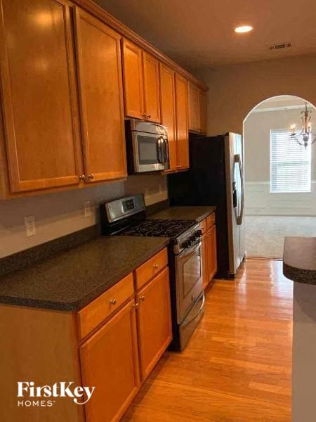 A kitchen with wooden cabinets and a black refrigerator.