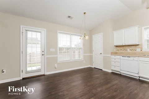 a kitchen with white cabinets and a hard wood floor