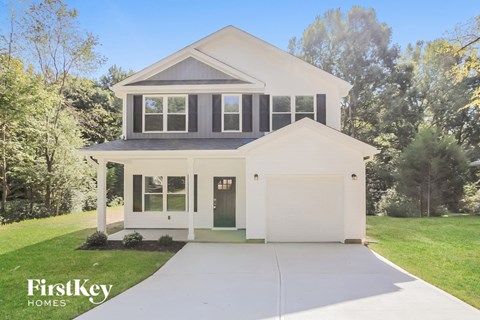 a white house with black shutters and a driveway