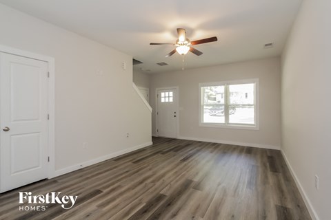 the living room of an empty house with a ceiling fan