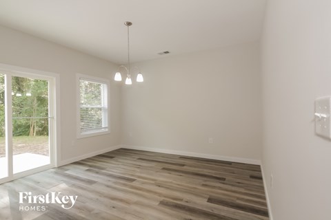 the living room of a house with wooden floors and white walls