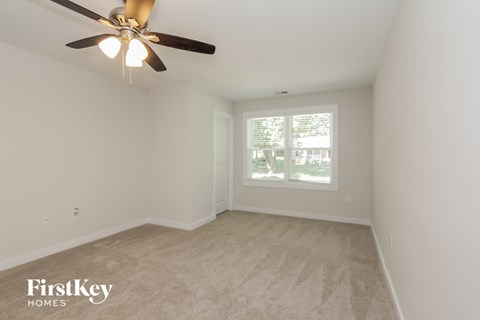 a bedroom with a ceiling fan and a window