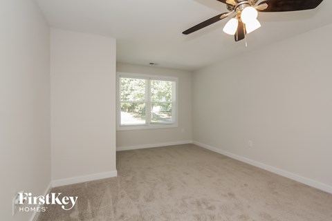 a empty room with a ceiling fan and a window