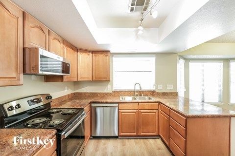 A kitchen with wooden cabinets and a stove top oven.