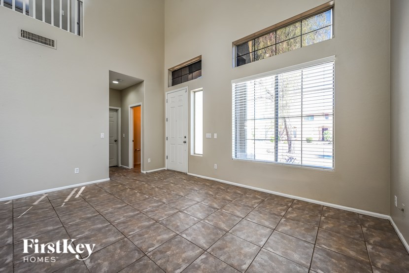 A room with a tile floor and a window with blinds.