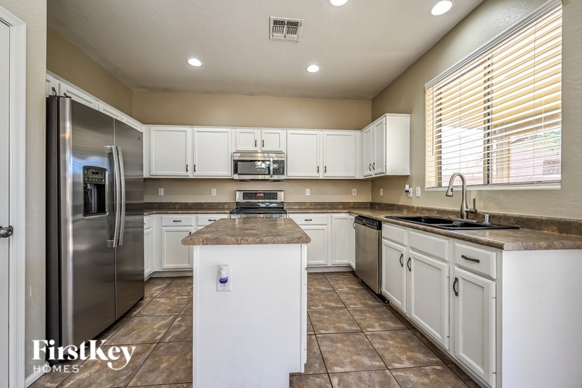 A kitchen with white cabinets and a stainless steel refrigerator.