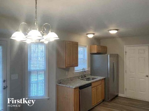 A kitchen with wooden cabinets and a stainless steel refrigerator.