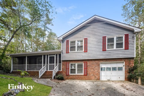 a renovated house with a white porch and a white garage door