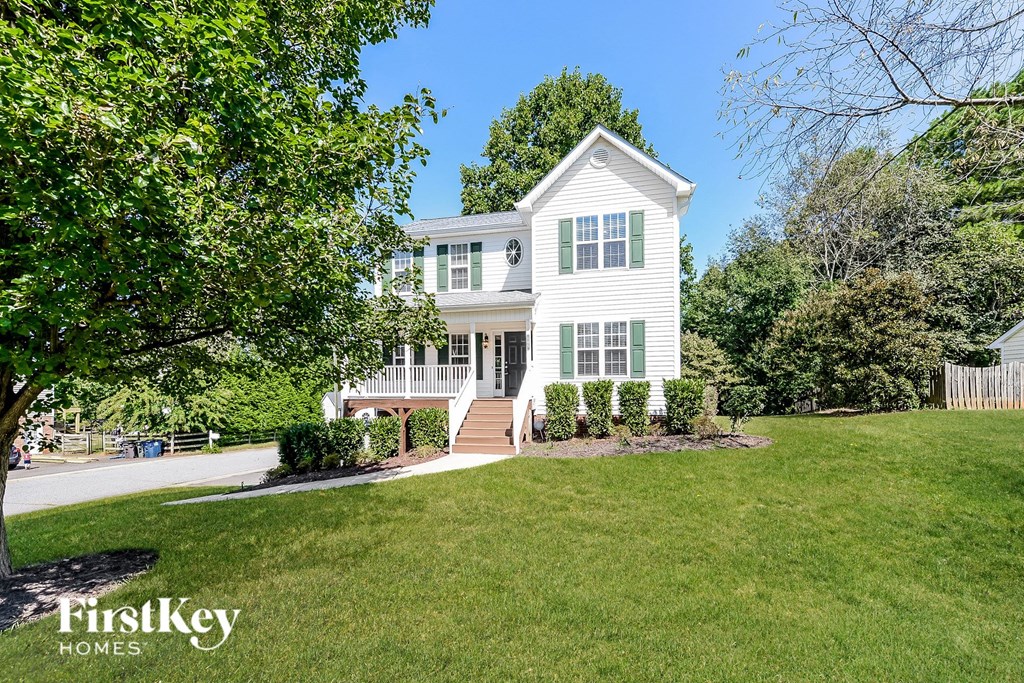 a white house with a lawn and trees
