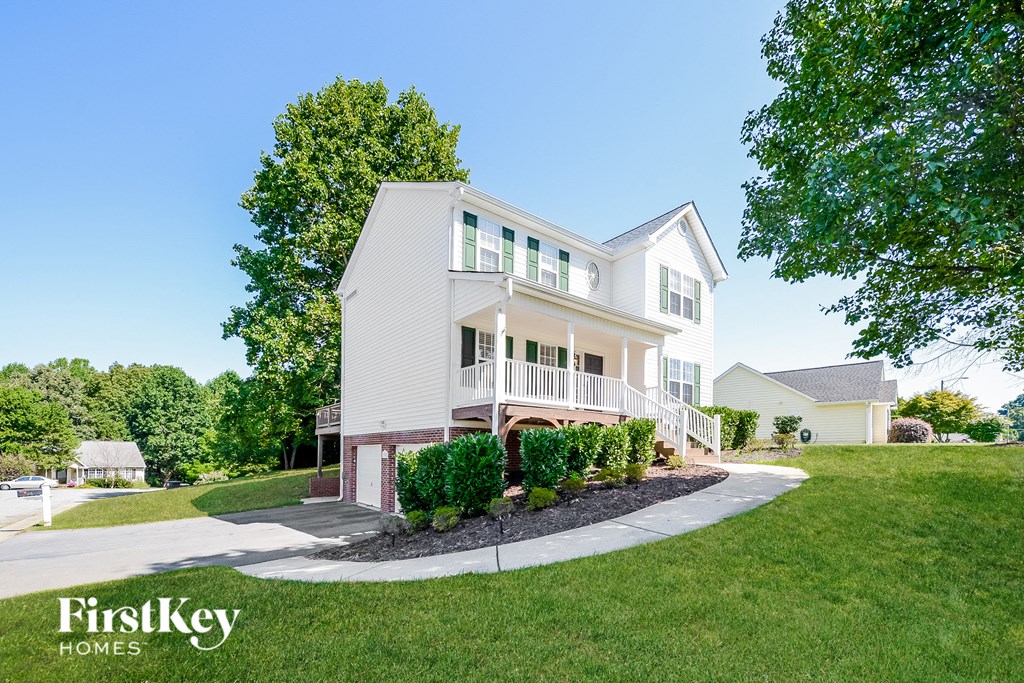 a white house with a white porch and a sidewalk