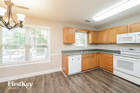 a kitchen with white appliances and wooden cabinets