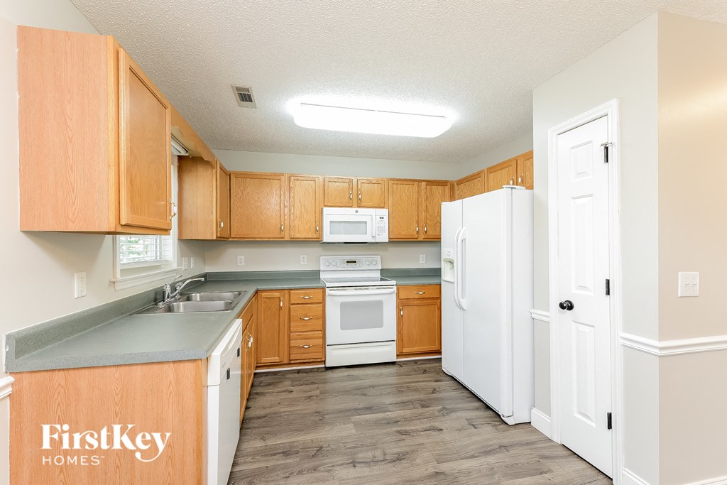 a kitchen with wooden cabinets and white appliances