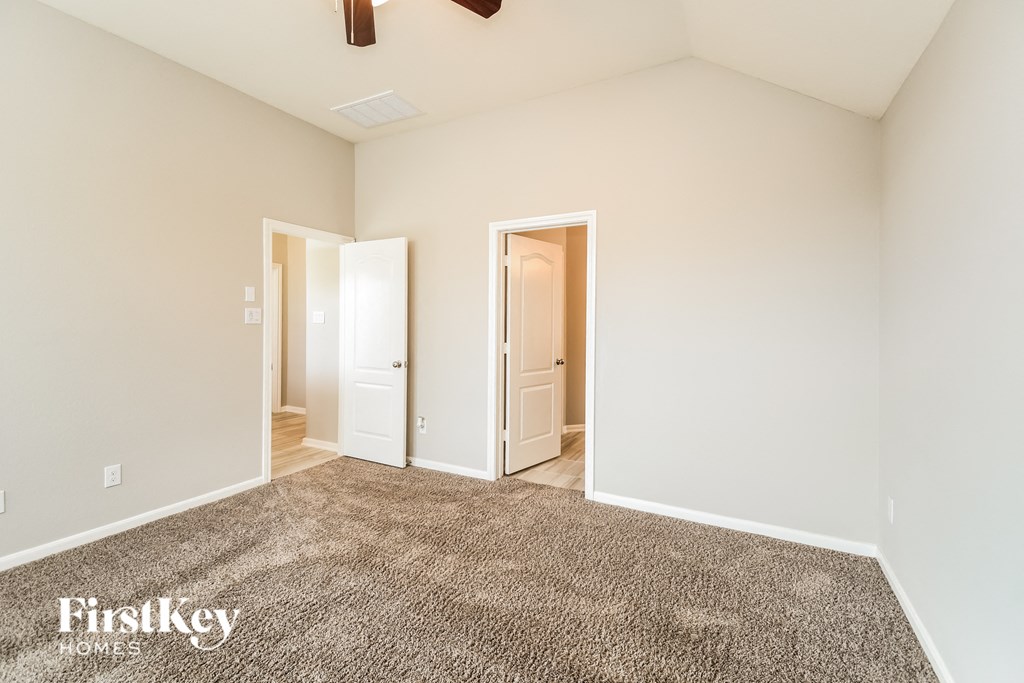 a bedroom with a carpeted floor and a door to a closet