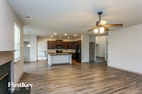a kitchen and living room with wood floors and a ceiling fan