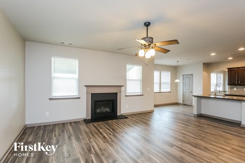 a living room with a fireplace and a ceiling fan