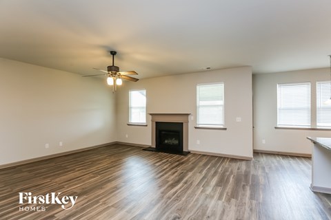 a living room with a fireplace and a ceiling fan