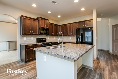 a kitchen with granite counter tops and wooden cabinets