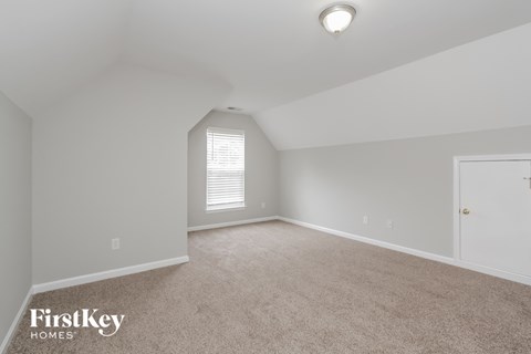 a bedroom with white walls and carpet and a white door