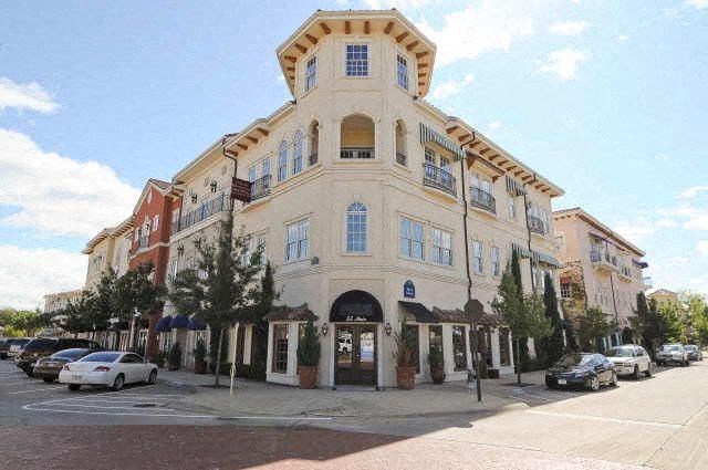 A large white building with a balcony on the second floor.