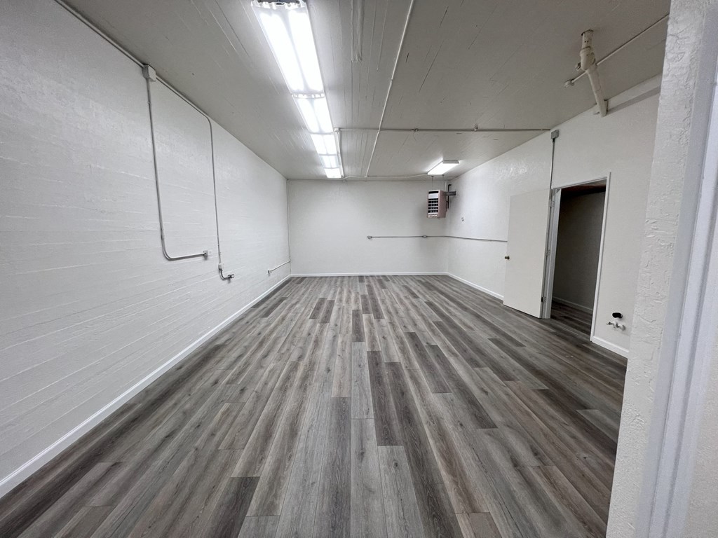 a large room with wood floors and white walls
