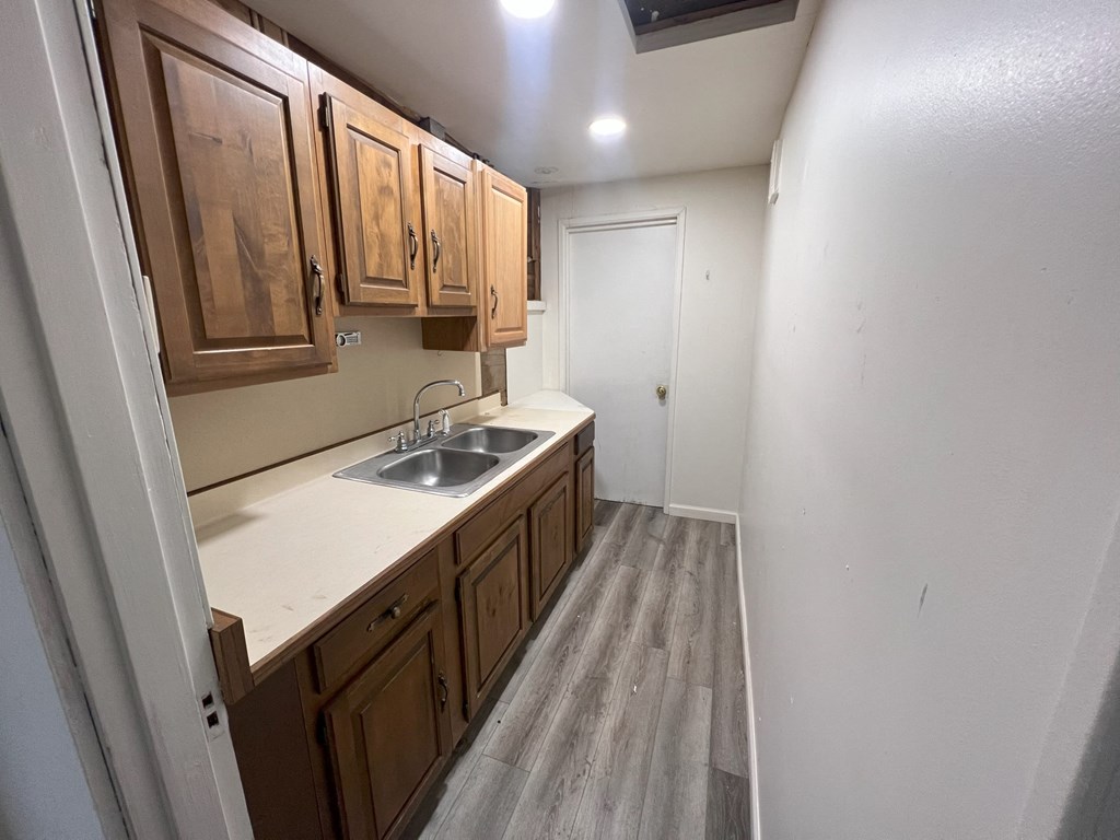 an empty kitchen with wooden cabinets and a sink