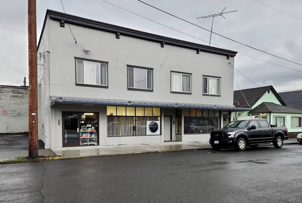 a black truck parked in front of a white building