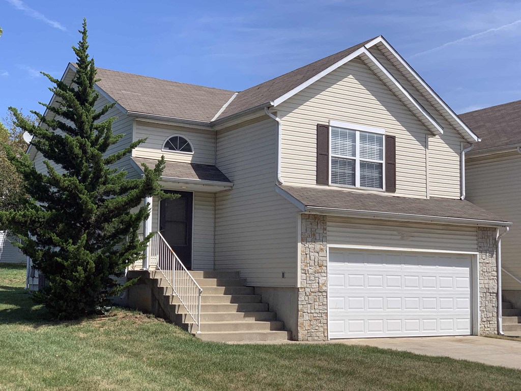 a tan house with a white garage door
