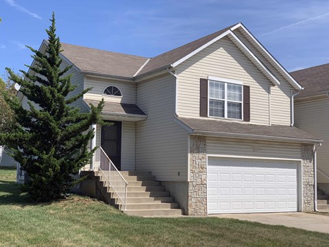 a tan house with a white garage door