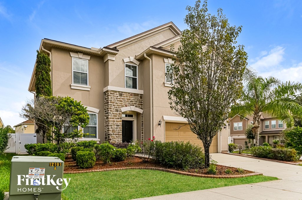 a beige house with a sidewalk in front of it