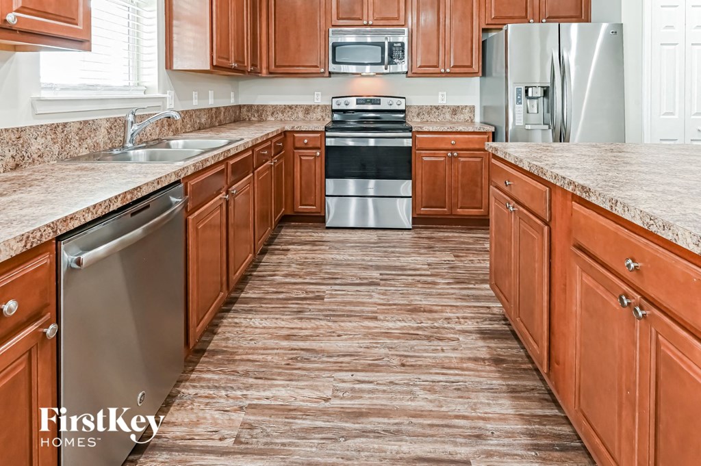 a kitchen with wood floors and wooden cabinets