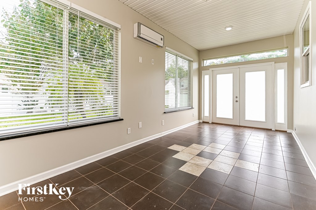 an empty living room with a large window and a door