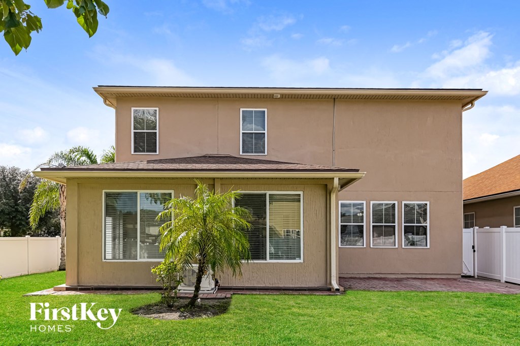 a beige house with a palm tree in the yard