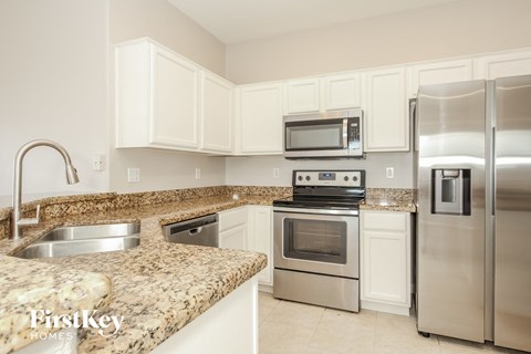 A kitchen with granite countertops and stainless steel appliances.