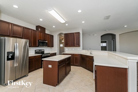 A kitchen with brown cabinets and a stainless steel refrigerator.