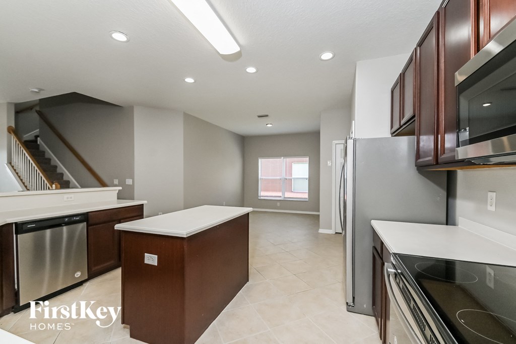 A kitchen with a stainless steel refrigerator and a white countertop.