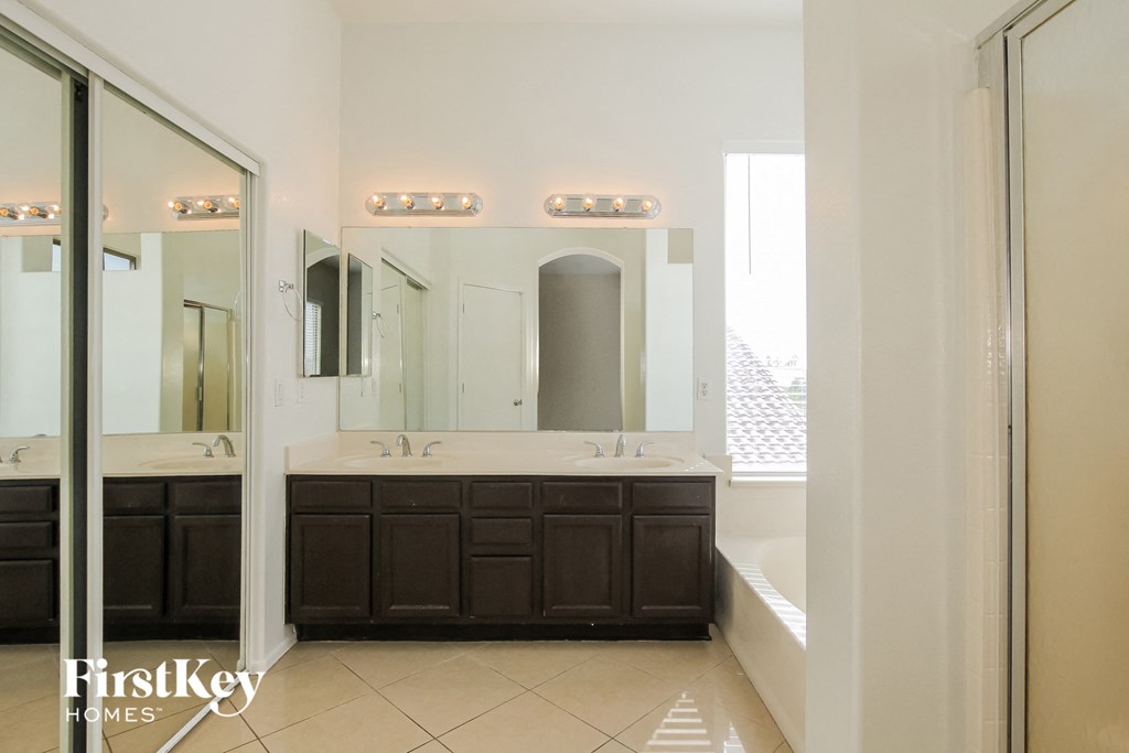 a bathroom with two sinks and a mirror and a tub