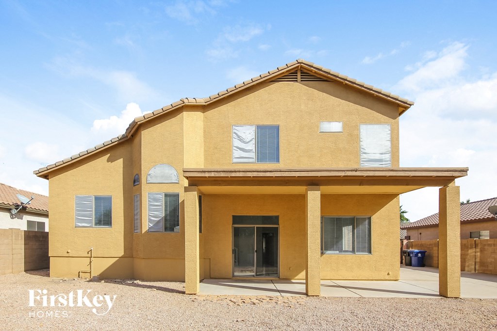 a yellow brick house with windows and a driveway