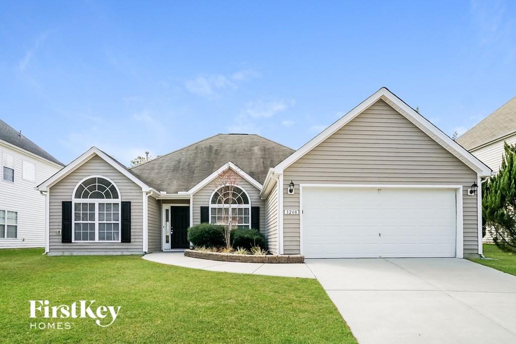 a beige and white house with a garage door and a lawn